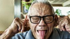 A elderly man pulling silly faces