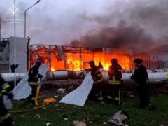 Lính cứu hỏa dập lửa tại một tòa nhà văn phòng bán lẻ ô tô, bị phá hủy trong một cuộc tấn công bằng tên lửa của Nga ở Zaporizhzhia, Ukraine ngày 11 tháng 10 năm 2022