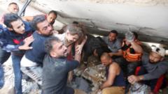 ဓါတ်ပုံ ၁။ ။ မေလ ၁၆ ရက်နေ့ အစ္စရေးရဲ့ လေကြောင်းတိုက်ခိုက်မှုကြောင့် ပြိုကျခဲ့တဲ့ အဆောက်အအုံ အပျက်အစီးများကြားက ကယ်ထုတ်နိုင်ခဲ့တဲ့ ကလေးငယ်