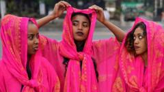 Three women dressed in traditional dresses of the Harari culture of eastern Ethiopia