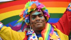 Участник парада в разноцветном венке на фоне радуги