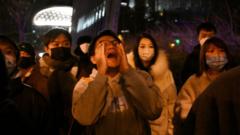 A protester shouts during a protest for the victims of a deadly fire as well as a protest against China's harsh Covid-19 restrictions in Beijing on November 28, 2022.