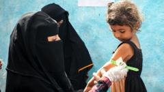A young girl has the circumference of her arm measured in Yemen