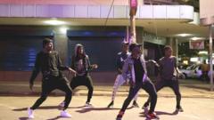 Cinco jovens dançam em rua