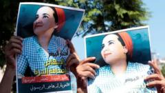 Moroccan activists hold posters of Hajar Raissouni at a protest outside the Rabat tribunal