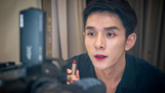 Li Jiaqi with his lips painted holds a lipstick