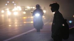 浓雾中，一个印度人站在新德里的路边