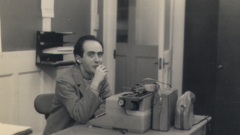 Vladimir Herzog sentado em frente a uma máquina de escrever na redação de Londres da BBC, em 1966, onde ele trabalhou por três anos