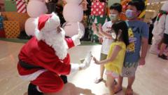 A man dressed as Santa Claus greets children at a shopping mall in Jakarta on December 25, 2020.