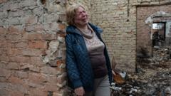 一名妇女在乌克兰奥泽拉被烧毁的房子里哭泣
