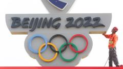 Workman stands next to Beijing 2022 logo