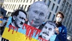 A protester holds a sign with pictures of Russian President Vladimir Putin, Adolf Hitler and Joseph Stalin, during an anti-war demonstration, amid Russia"s invasion of Ukraine, in Hamburg, Germany, March 20, 2022.