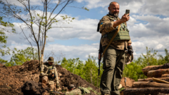 A Ukrainian soldier communicates on a mobile phone using Starlink