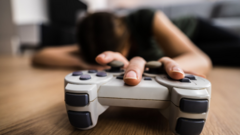 Person resting with hand on game's controller