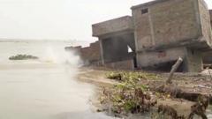 Watch: Building collapses into river in India