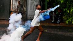 A demonstrator throws back a tear gas canister fired by police to disperse students taking part in an anti-government protest demanding the resignation of Sri Lanka's President Gotabaya Rajapaksa over the country's crippling economic crisis, in Colombo on 29 May, 2022.