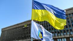 The Ukrainian flag and Ukrainian Olympic Committee flag outside the organisation's headquarters