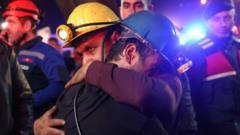 Two miners hug, surrounded by emergency workers