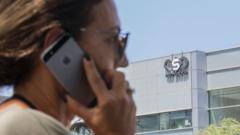 Umugore wo muri Israel akoresha telefone ya iPhone imbere y'inyubako ikoreramo kompanyi NSO group, ku itariki ya 28 y'ukwa munani mu 2016, i Herzliya, hafi y'umujyi wa Tel Aviv.
