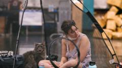 A woman and her cat rest inside a tent at the Oregon Convention Center cooling station in Oregon, Portland on June 28, 2021, as a heatwave moves over much of the United States.