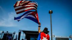 Una persona ondea las banderas de Cuba y EE.UU.