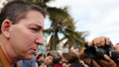 O jornalista Glenn Greenwald aparece de perfil durante manifestação no Rio de Janeiro, com fotógrafo no plano de fundo