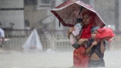 People wade through the water as they look for shelter during a flood, amidst heavy rains that caused widespread flooding in the northeastern part of the country, in Sylhet, Bangladesh, June 18, 2022.