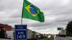 bandeira do brasil em rodovia com caminhões parados