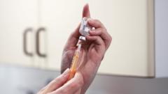 A nurse prepares a syringe of the AstraZeneca vaccine