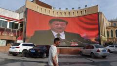 A man walks past a screen showing images of Chinese President Xi Jinping in Xinjiang