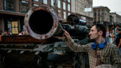 In this photograph taken on 21 August 2022 a man looks at a destroyed Russian tank at Khreshchatyk street in Kyiv, that has been turned into an open-air military museum ahead of Ukraine's Independence Day on 24 August, amid Russia's invasion of Ukraine.