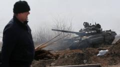 A man walks along a road past a tank of pro-Russian troops during Ukraine-Russia conflict on the outskirts of the besieged southern port city of Mariupol, Ukraine 20 March 2022