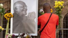 A mourner leaves flowers in tribute to Archbishop Desmond Tutu