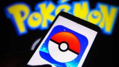 The Pokemon Go app logo on a phone in front of the Pokemon lettering logo