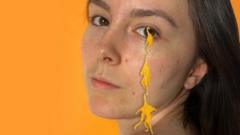 Chloe with acrylic creatures dangling from her eyelash which were coloured using bacteria