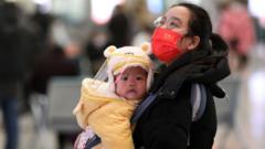A woman holds a baby at Shijiazhuang Railway Station on the first day of 2023 China's Spring Festival travel rush on January 7, 2023 in Shijiazhuang, Hebei Province of China. The 40-day Spring Festival travel rush officially starts on January 7.