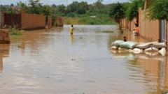 Pikin dey waka inside water for one street wey flood for Kirkissoye quarter for Niamey