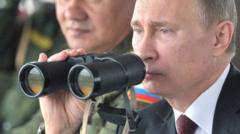 Russian President Vladimir Putin (R) and Defence minister Sergei Shoigu (L) inspect military exercises in the Pacific Ocean near the Sakhalin island on July 16, 2013