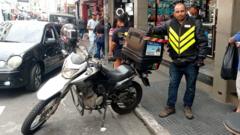 Renan de Lira Rodrigues ao lado da moto dele
