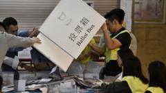 香港屯门一处区议会选举投票站工作人员从投票箱倒出选票准备点票（24/11/2019）
