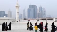 With Dubai's trademark skyscrapers in the background, Muslim women walk past a minaret