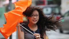 颱風韋森特迫近香港之際一位女士持傘狼狽走過街頭（23/7/2012）