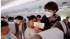 A passenger takes photos of a card during the first commercial flight of China's first domestically produced passenger jet C919