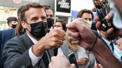 French President Emmanuel Macron (L) and his wife Brigitte Macron (C) salute people in Valence, France, 08 June 2021