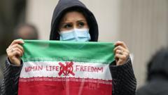 伦敦特拉法加广场一位女士举起写上“女性、生命、自由”字样的伊朗国旗抗议（29/10/2022）