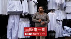 聖薩爾瓦多一位女士站在一家專門售賣囚衣的店鋪前（31/5/2022）