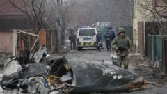 A soldier walks past the debris of a military plane that was shot down overnight in Kiev, Ukraine, 25 February 2022