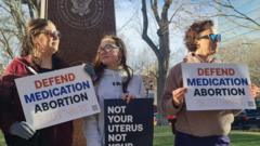 Protesters in Texas hold signs reading 'defend medical abortion'