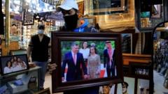 A frame maker in a frameshop displays a picture of king Abdullah II bin Al-Hussein king of Jordan, in Amman