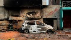A burnt-out vehicle is pictured following clashes between people supporting and opposing a contentious amendment to India's citizenship law, in New Delhi on February 26, 2020